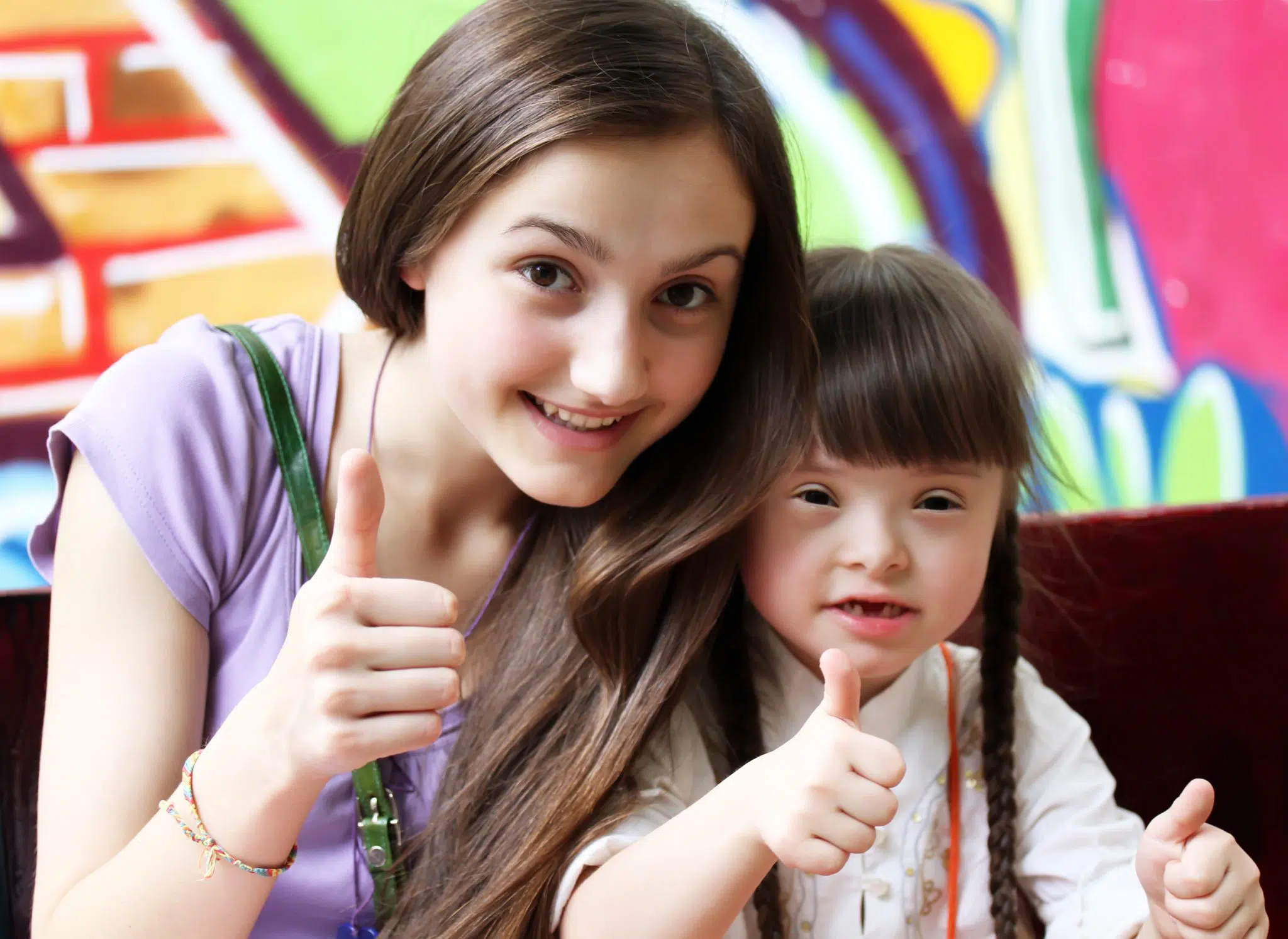 A young girl spending time with a toddler