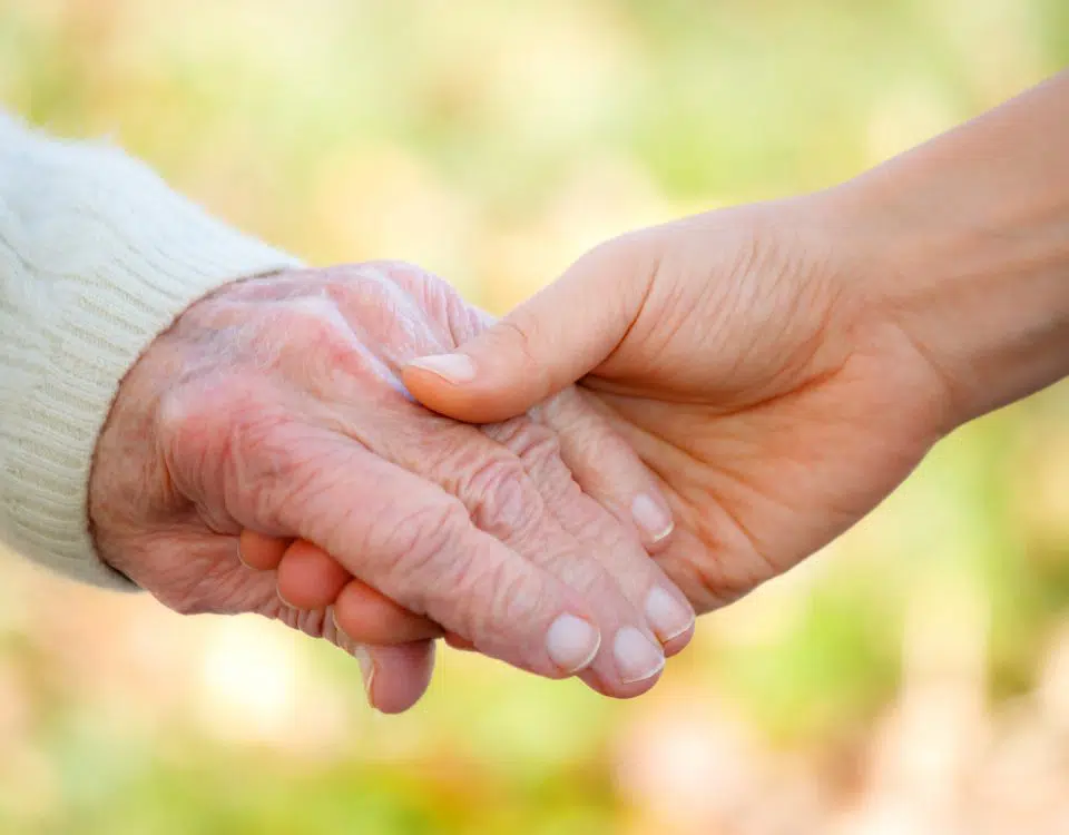 Senior and young holding hands