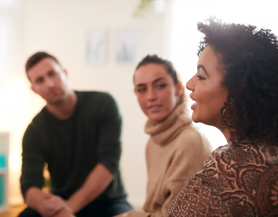 woman talking with two others in group setting