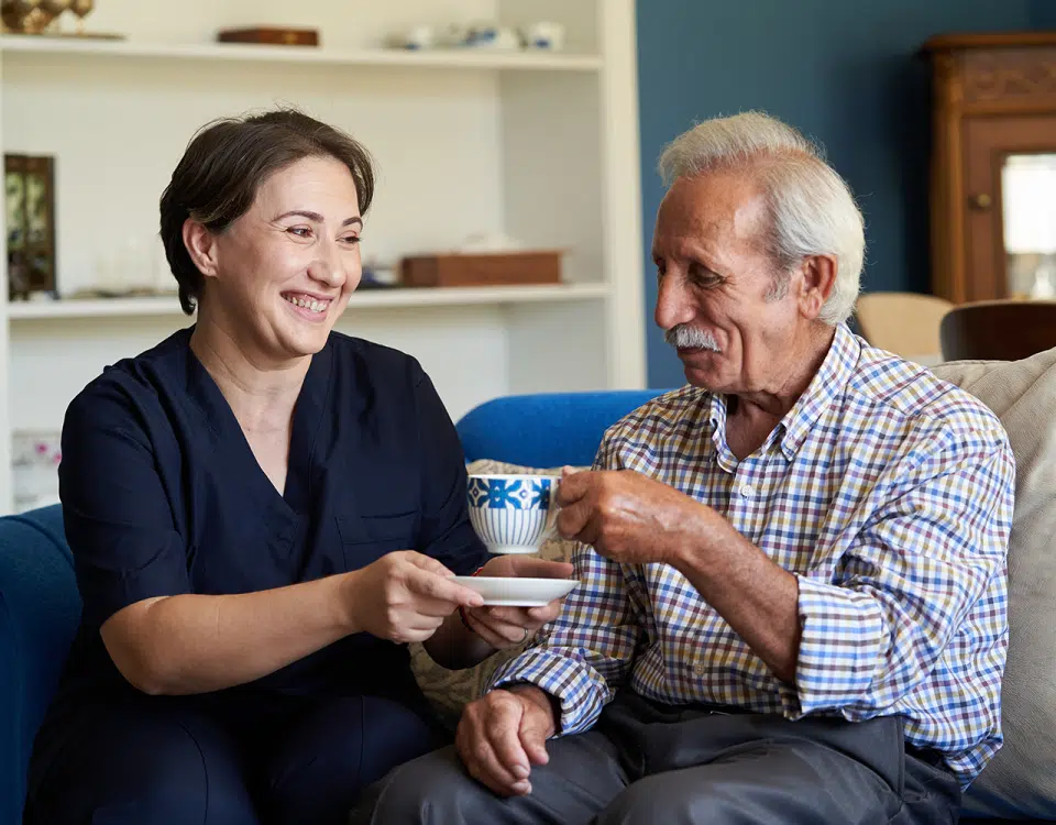 nursing handing man cup of tea